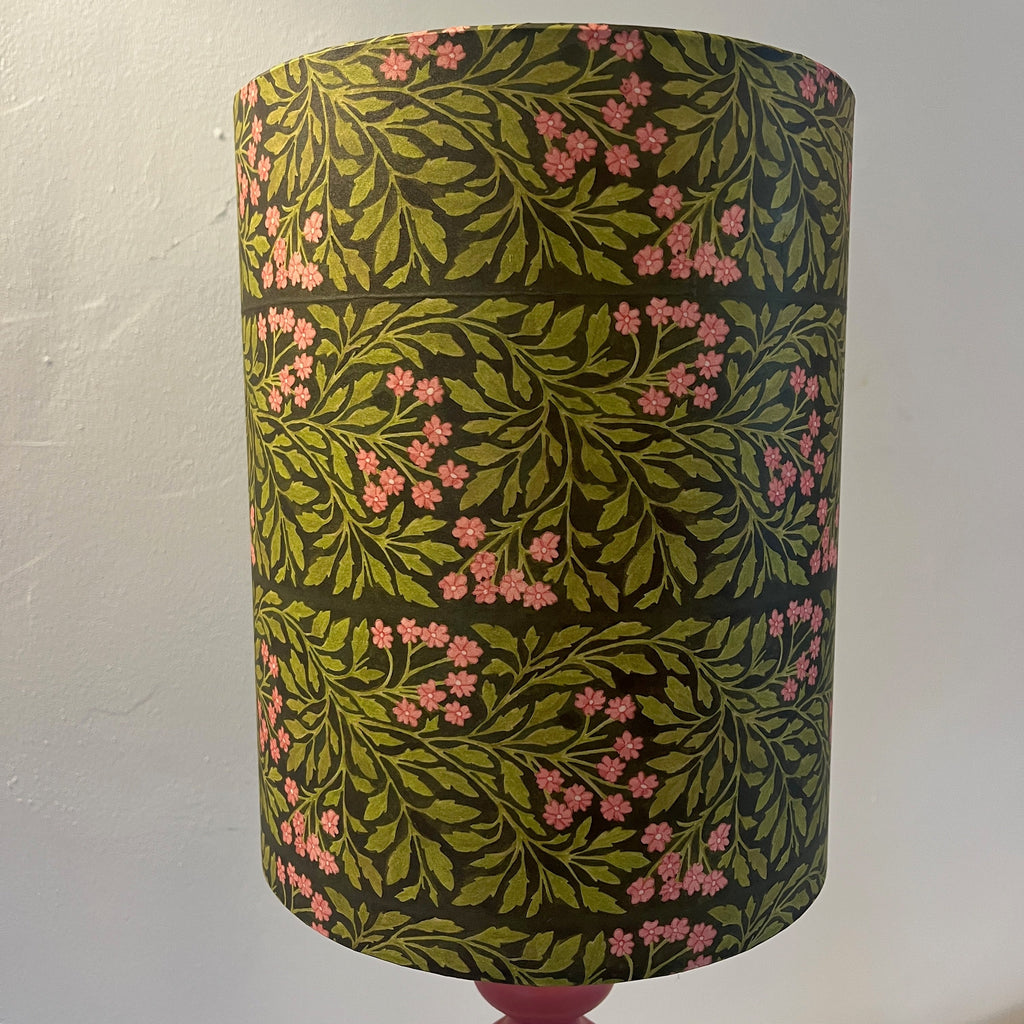 A William Morris-inspired lampshade featuring a harmonious blend of soft pink and lush green hues, adorned with intricate floral and vine patterns, evoking the timeless beauty of Arts and Crafts design